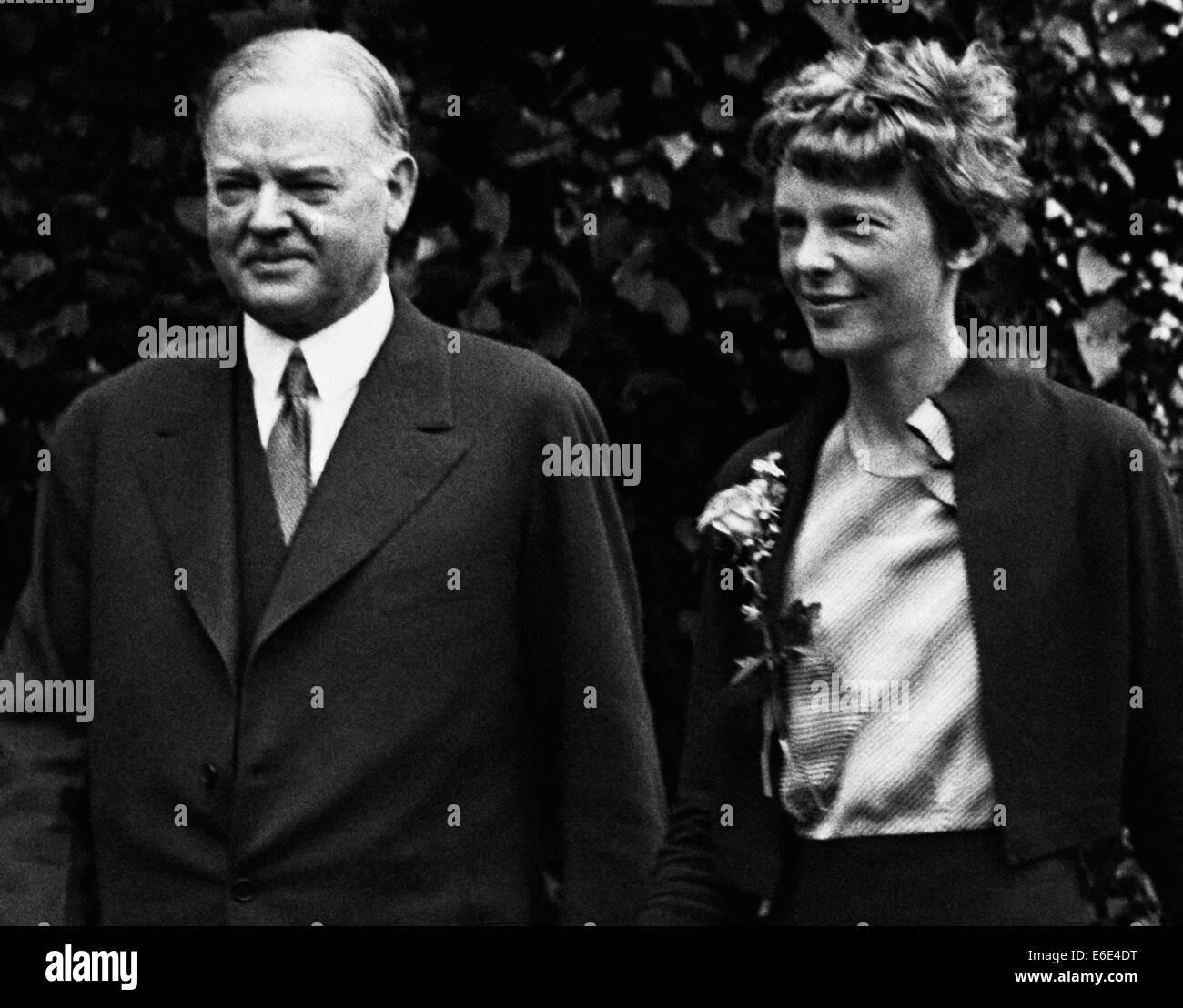 Vintage photo of American aviation pioneer and author Amelia Earhart (1897 – declared dead 1939) – Earhart and her navigator Fred Noonan famously vanished in 1937 while she was trying to become the first female to complete a circumnavigational flight of the globe. Earhart is pictured with President Herbert Hoover at The White House in June 1932 where Hoover presented her with a National Geographic Society gold medal in recognition of her non-stop solo flight across the Atlantic. Stock Photo