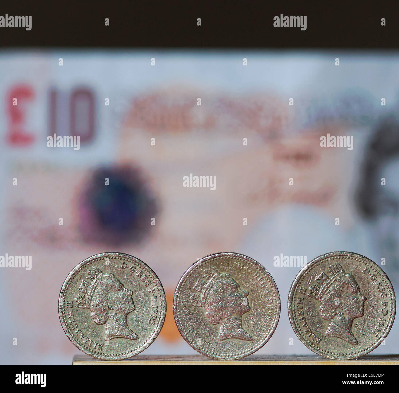 £1 British Stirling coins are pictured in front of a £10 British ...