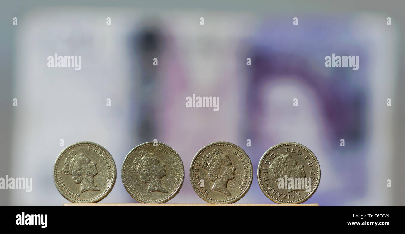 £1 British Stirling coins are pictured in front of a £20 British ...