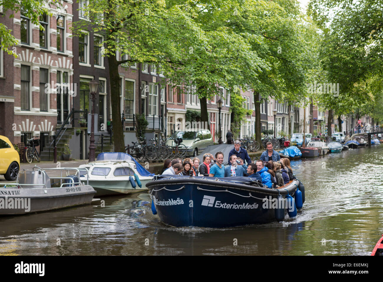 People enjoying a boat trip on one of the canals in the Jordaan (Egelantiers Gracht), Amsterdam in the Netherlands Stock Photo