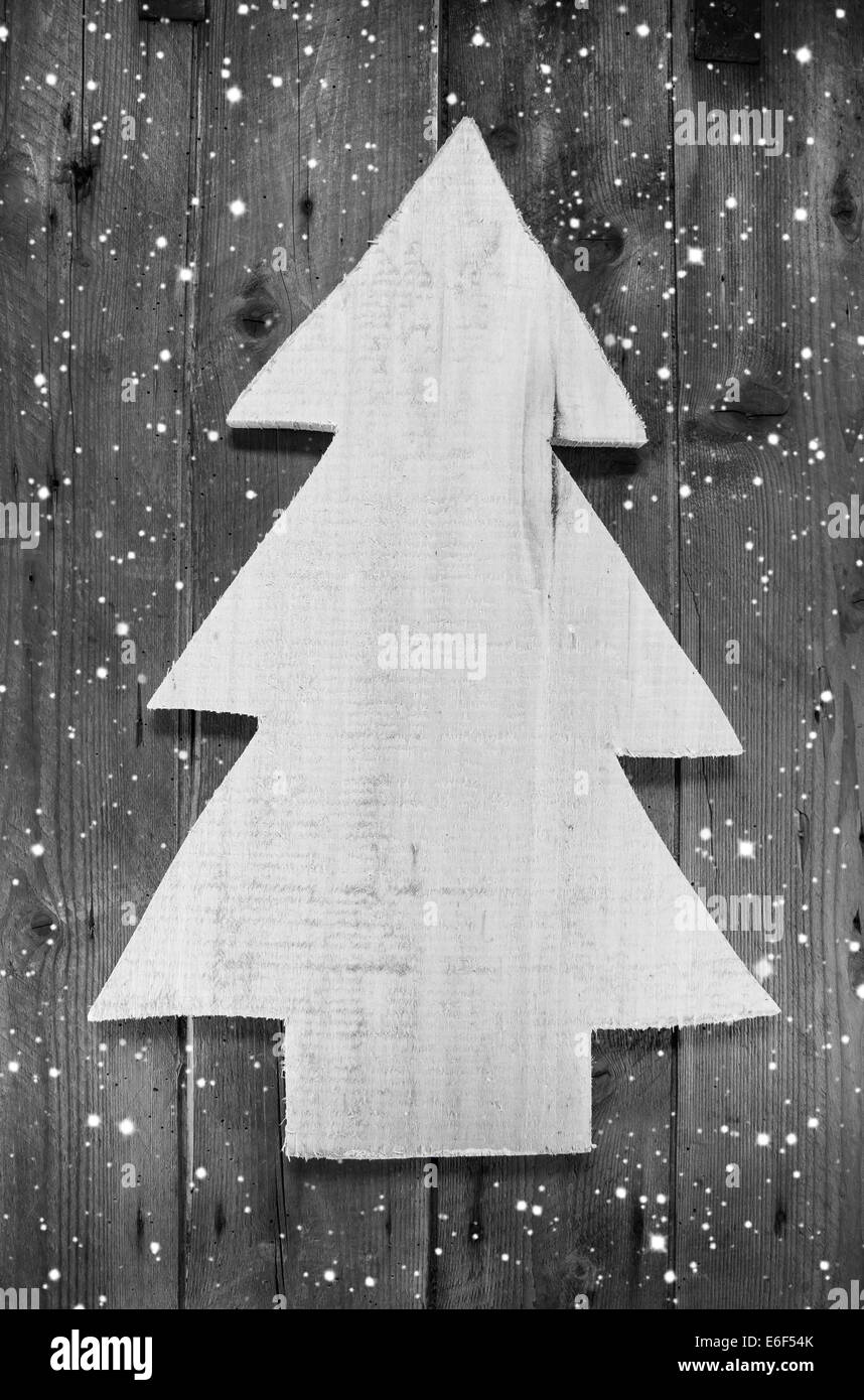 Wooden grey and white christmas tree in shabby style on a wood snowy background for a greeting card. Stock Photo