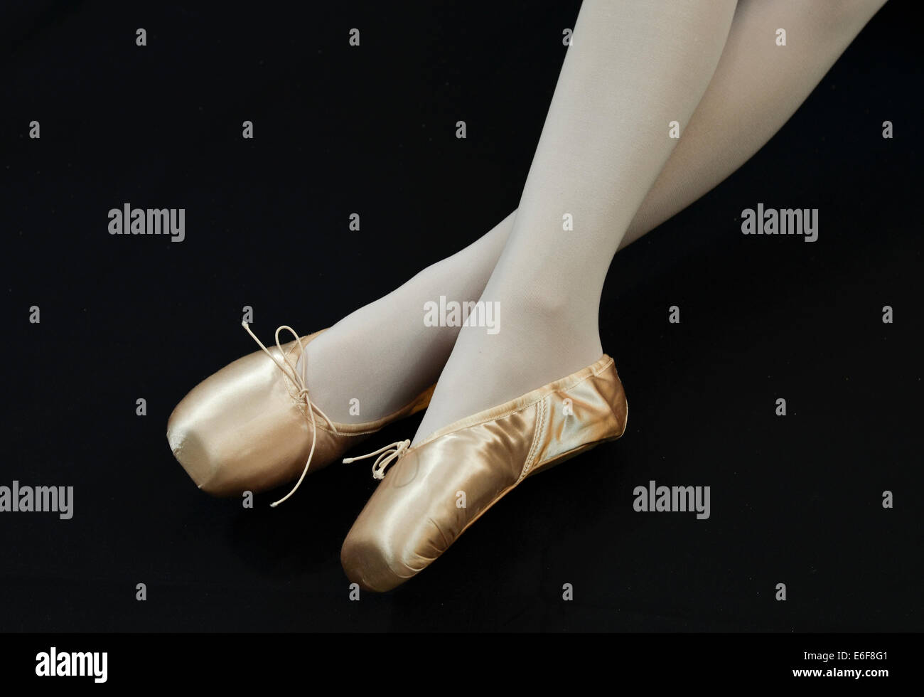 Ballerina's feet in ballet shoes on black background Stock Photo