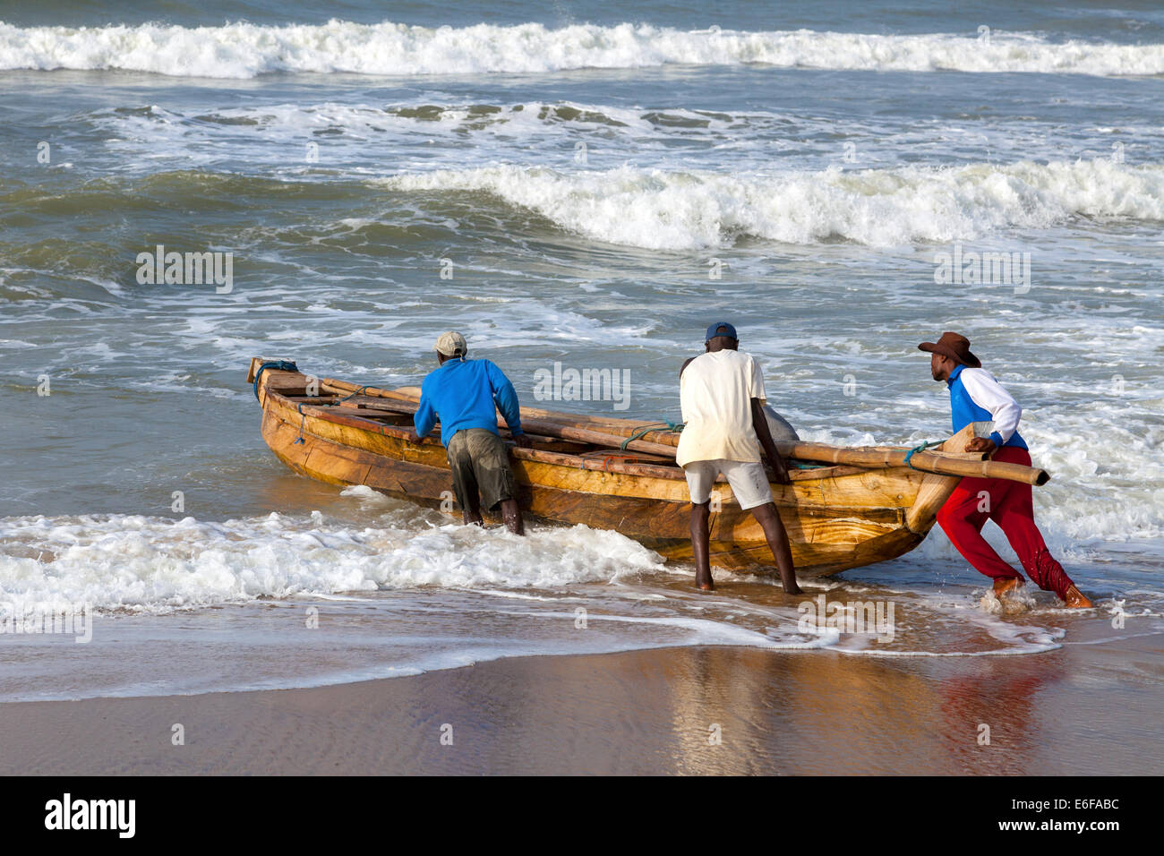 Fishermen launching a fishing boat at Prampram, Greater Accra, Ghana, Africa Stock Photo