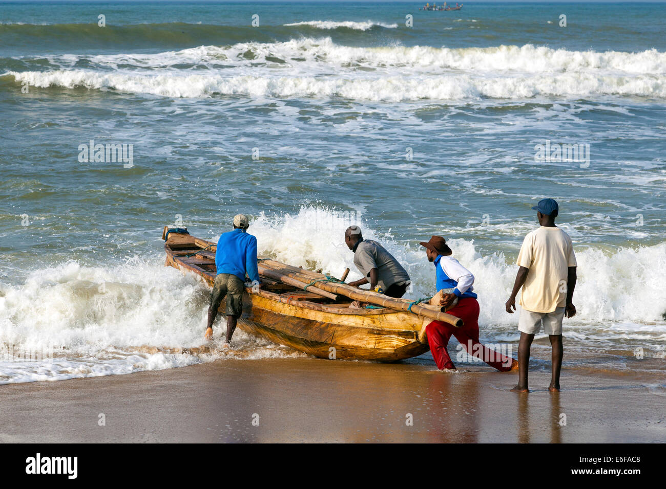 Fishermen launching a fishing boat at Prampram, Greater Accra, Ghana, Africa Stock Photo