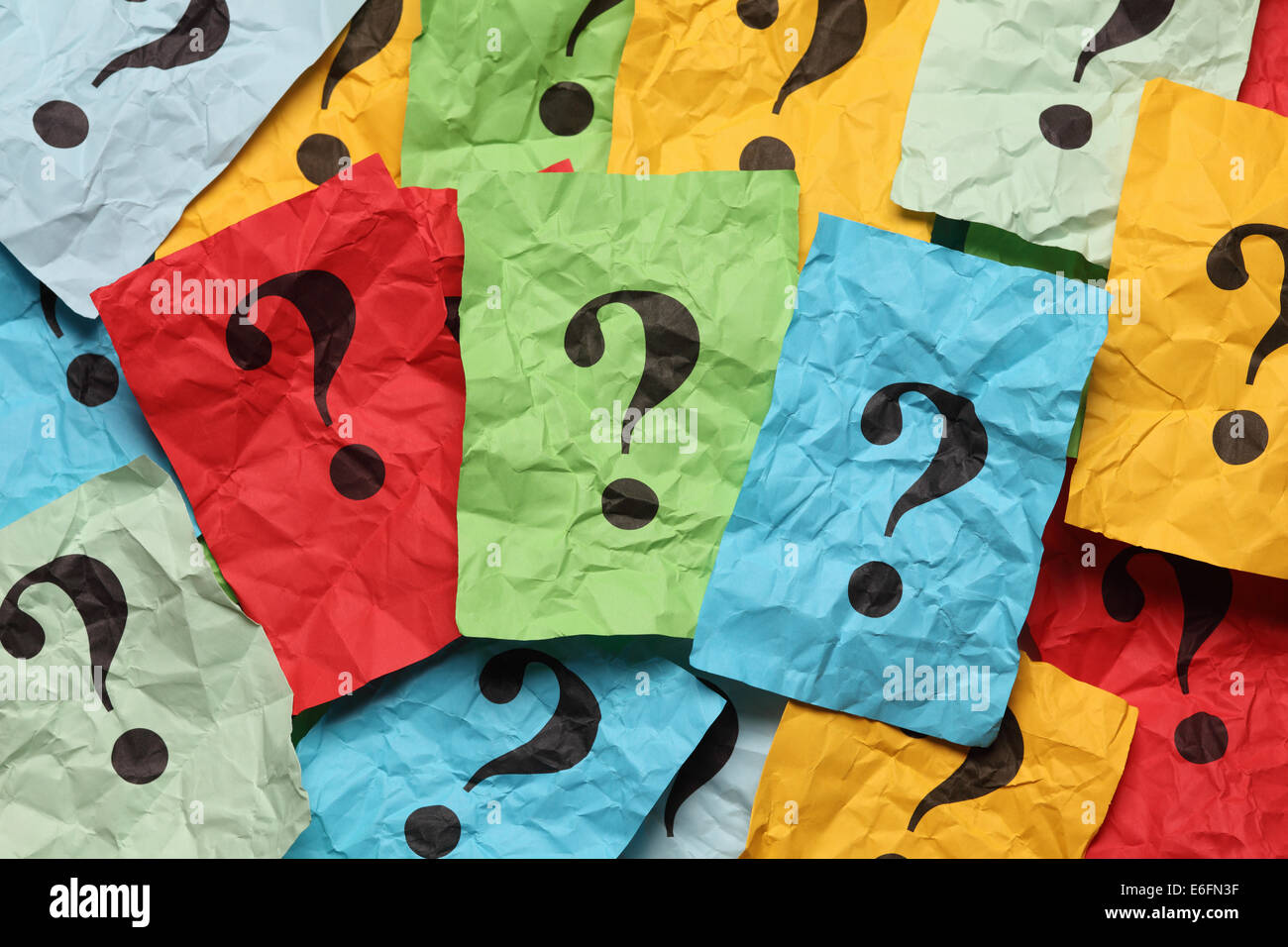 Crumpled colorful paper notes with question marks. Stock Photo
