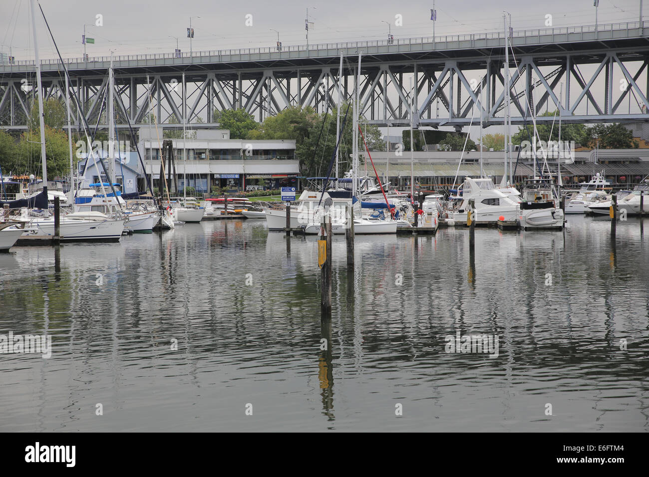 Yacht parked on false creek in Vancouver, with Granville bridge behind Stock Photo