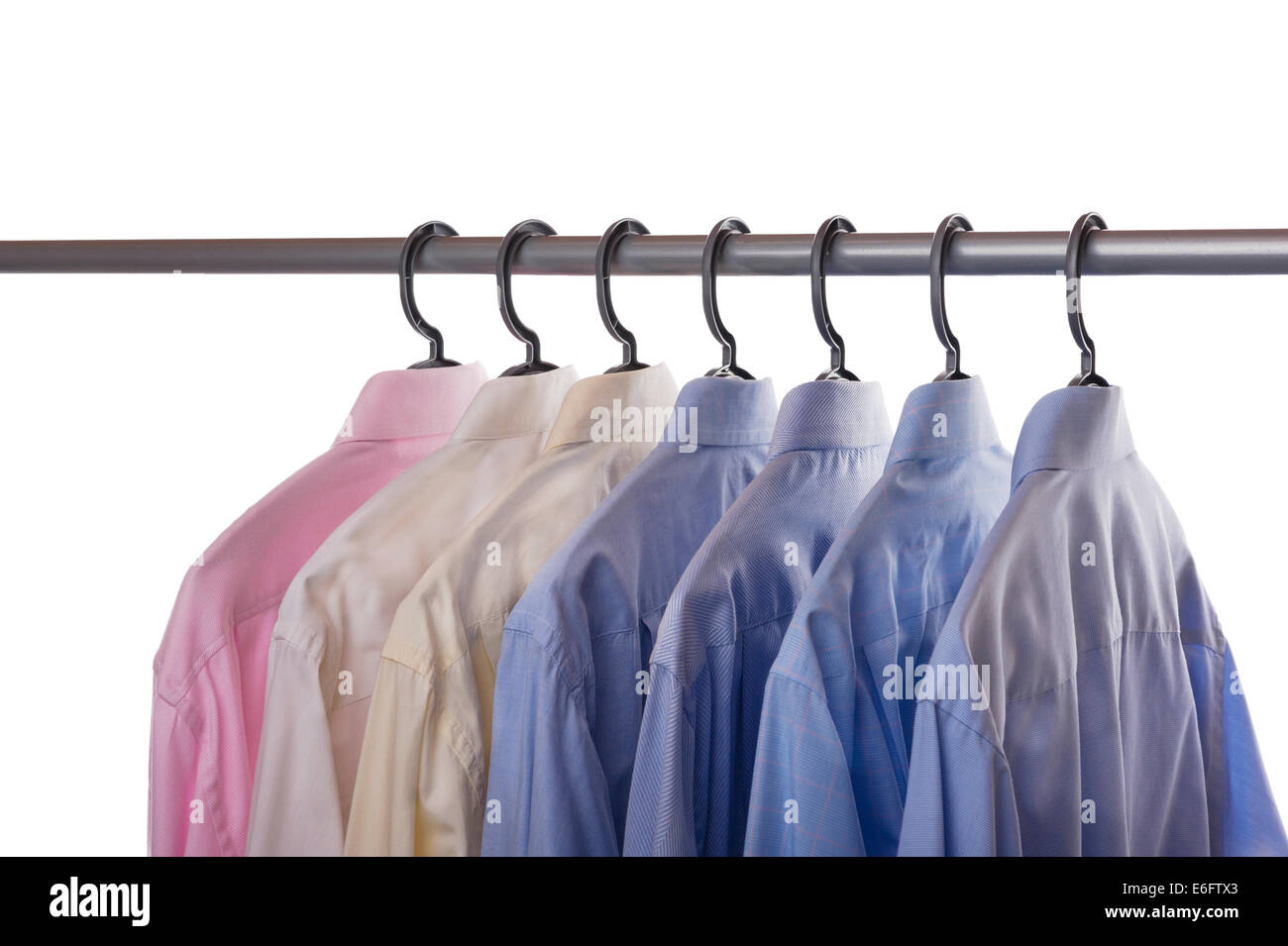 Seven mens shirts hanging on a clothing rail. Stock Photo