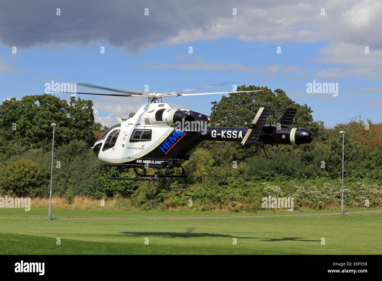 West Ewell, Epsom, Surrey, UK. 22nd Aug, 2014. Residents of West Ewell had a suprise this afternoon as the KSSA (Kent Surrey Sussex Air ambulance) landed on an area of the Hogsmill Open Space between Riverview School and the Watersedge Estate. It landed at 13.30 in response to 'A medical Emergency' on the estate. Locals gathered to see the unusual site of a helicopter so close to nearby housing, and as it was summer holiday time many curious childern were keen to witness the event. Credit:  Julia Gavin UK/Alamy Live News Stock Photo