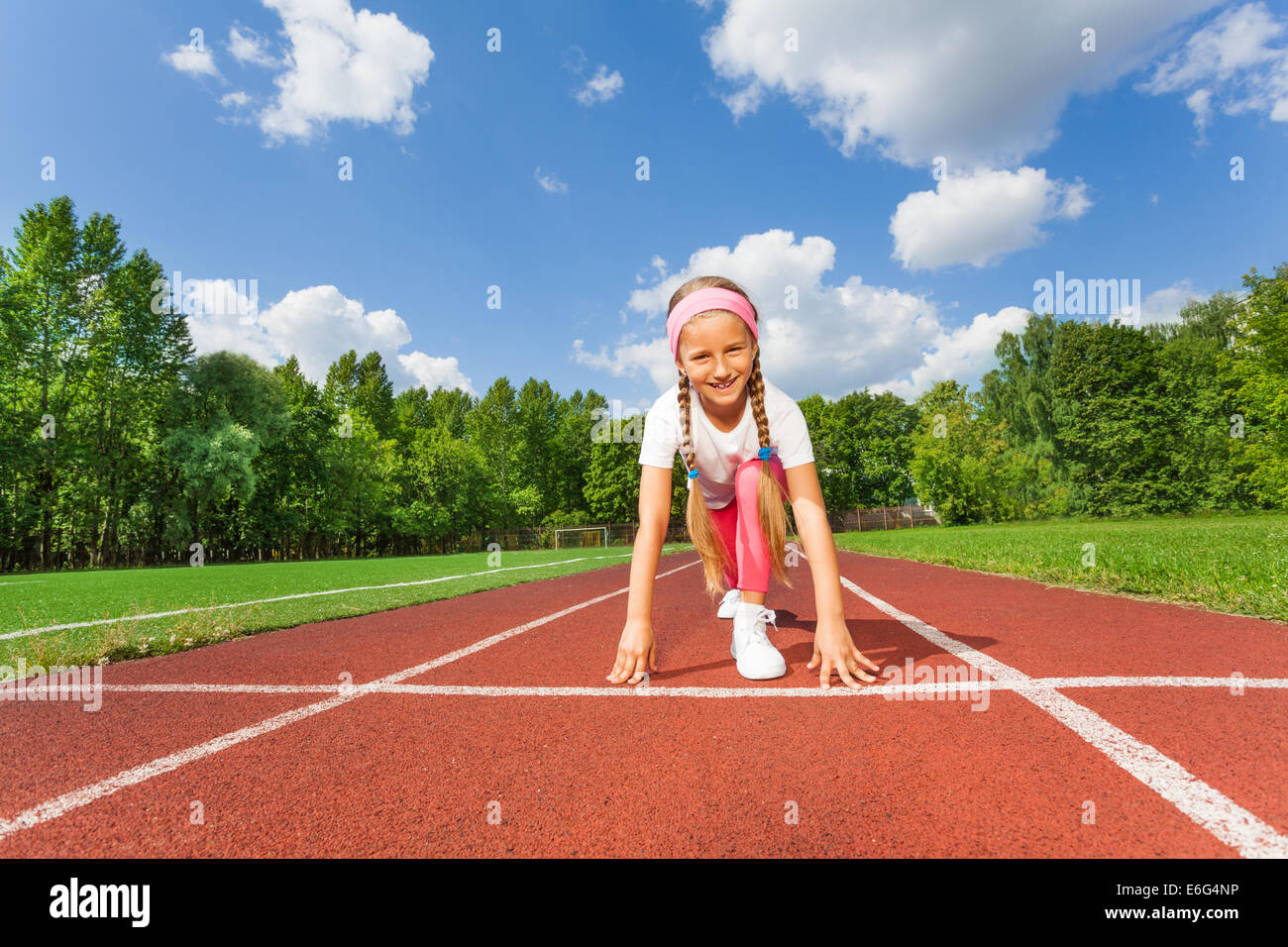 Girl in ready position on bend knee to run Stock Photo