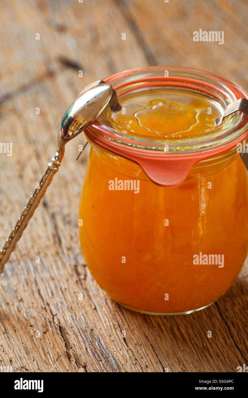 Homemade melon jam in a preserving jar with a spoon on old wooden table Stock Photo