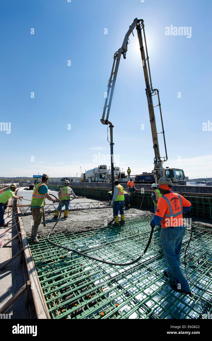 Workers pouring concrete for new highway overpass on I-95 Harbor Crossing Project. Stock Photo