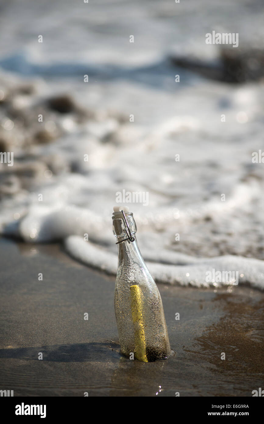 Message in a bottle on a sandy beach Stock Photo