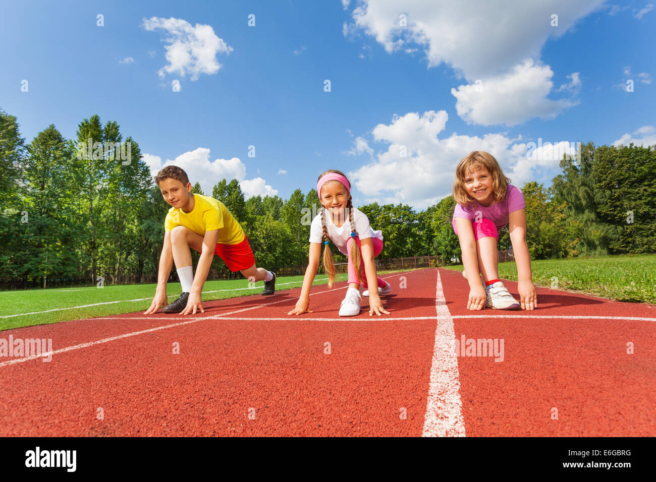Smiling children in ready position to run Stock Photo