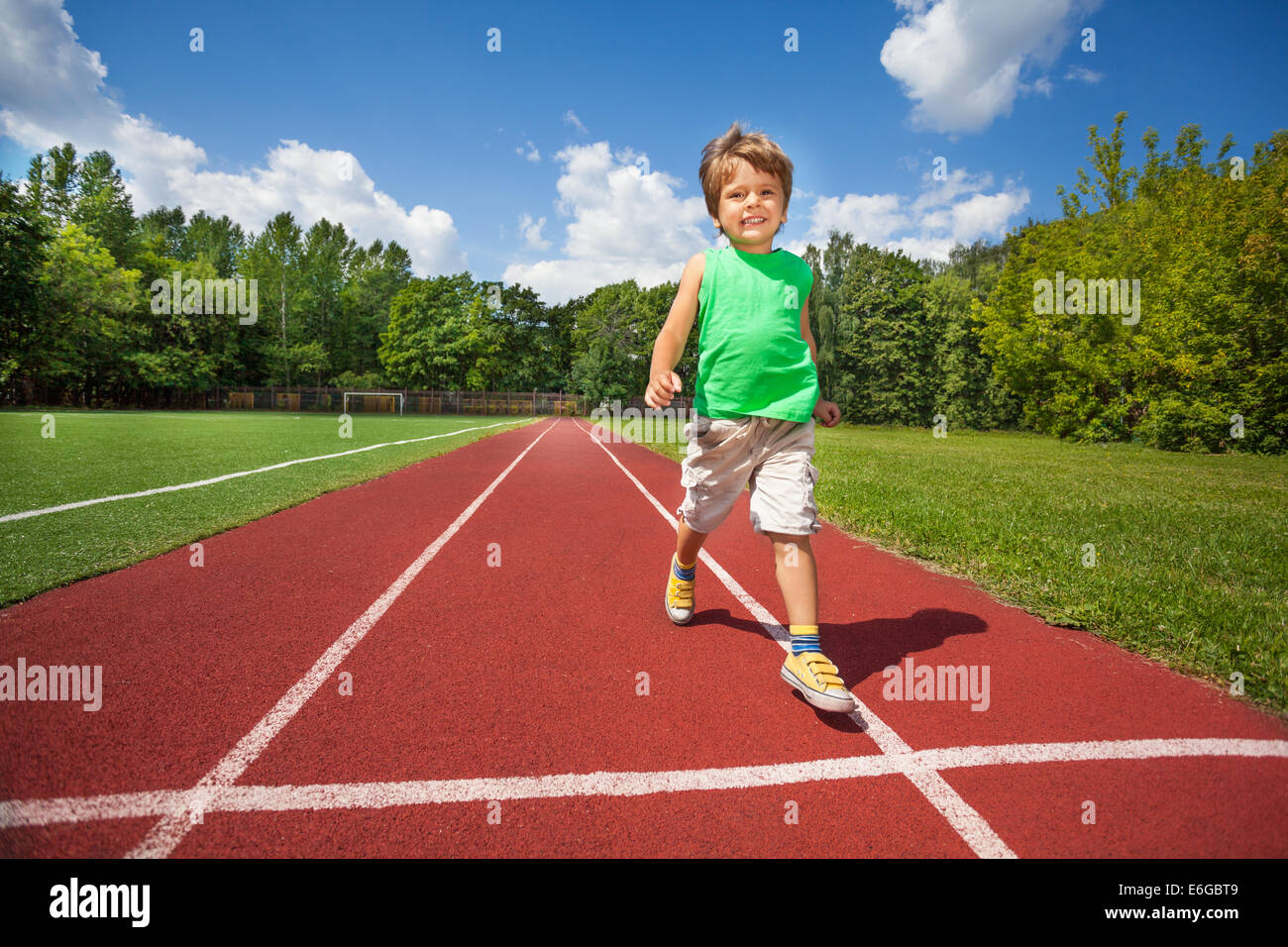 Cute small boy runs slowly on the marathon road Stock Photo