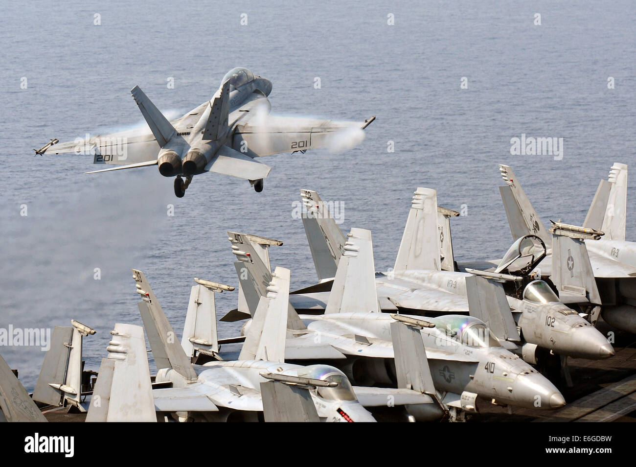 A US Navy F/A-18F Super Hornet fighter aircraft takes off from the flight deck of the aircraft carrier USS George H.W. Bush on a mission to support the Iraqi military August 16, 2014. President Obama authorized targeted airstrikes to protect U.S. personnel from extremists known as the Islamic State in Iraq and the Levant. Stock Photo