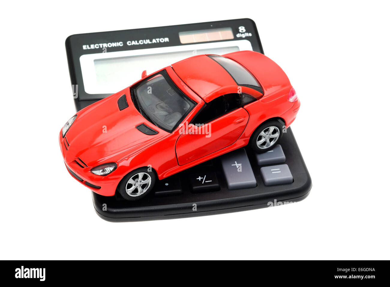 A red sports car placed on a calculator - studio shot with a white background and a shallow depth of field Stock Photo
