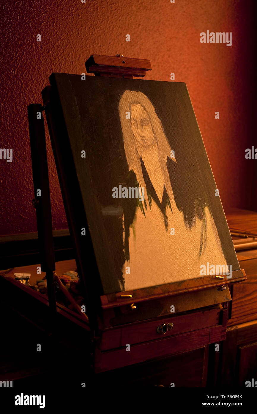 Painting of young woman on easel in artist studio with window light ...