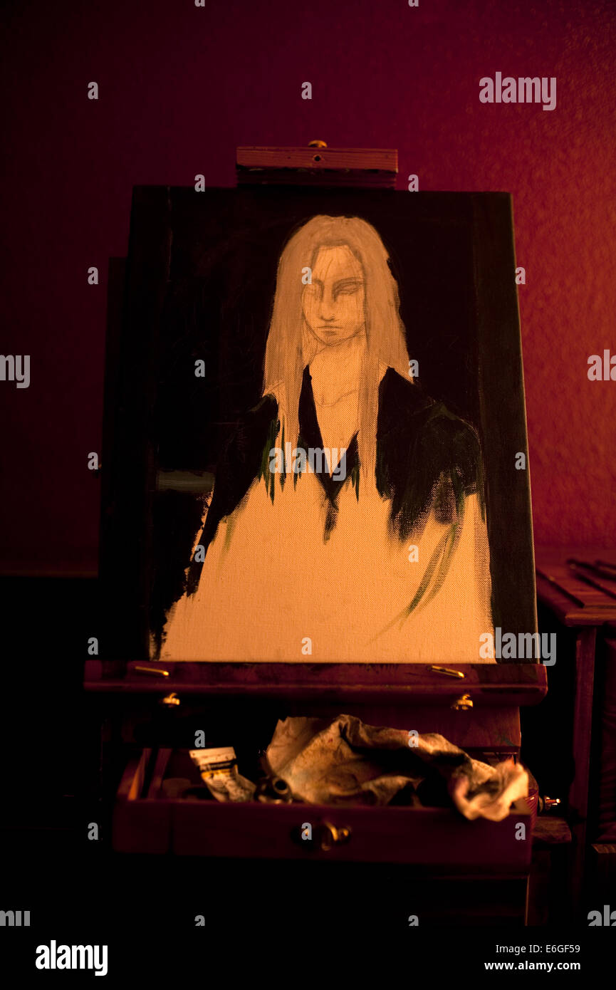 Painting of young woman on easel in artist studio with window light ...