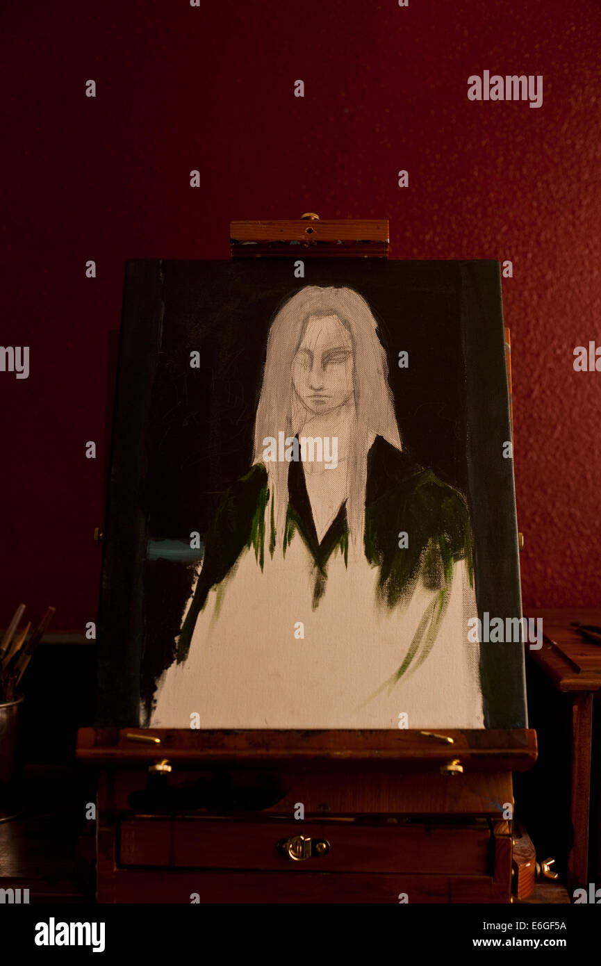 Painting of young woman on easel in artist studio with window light ...