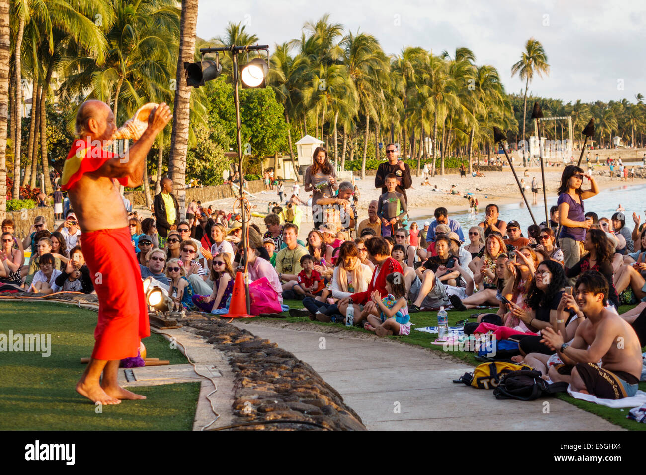 Hawaii,Hawaiian,Honolulu,Waikiki Beach,Kuhio Beach Park,Hyatt Regency Hula Show,performers,free man men male,blowing conch shell,audience,USA,US,Unite Stock Photo