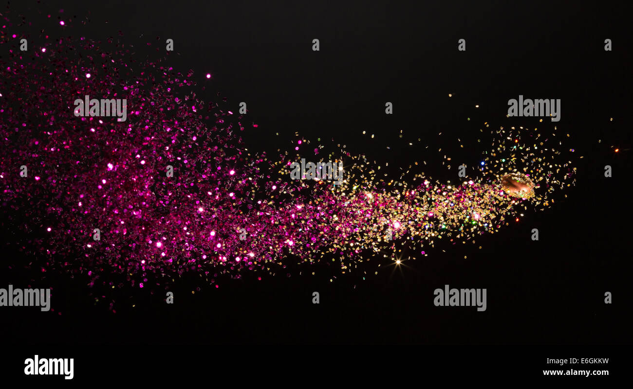 Mix of powder dye and glitter captured mid-flight in high speed as it's shoot from a custom glitter cannon Stock Photo