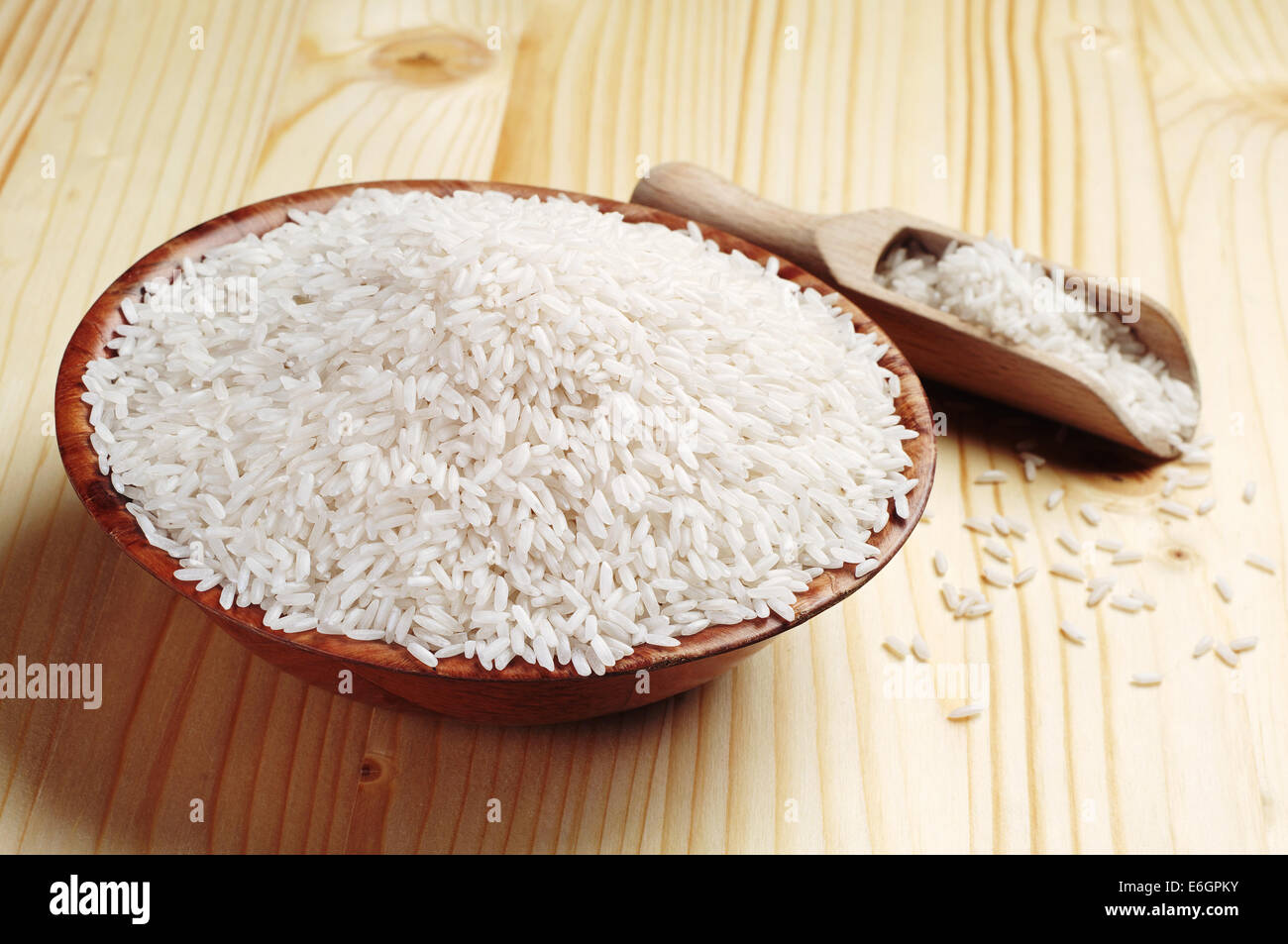 Rice in a bowl and scoop on wooden table Stock Photo - Alamy