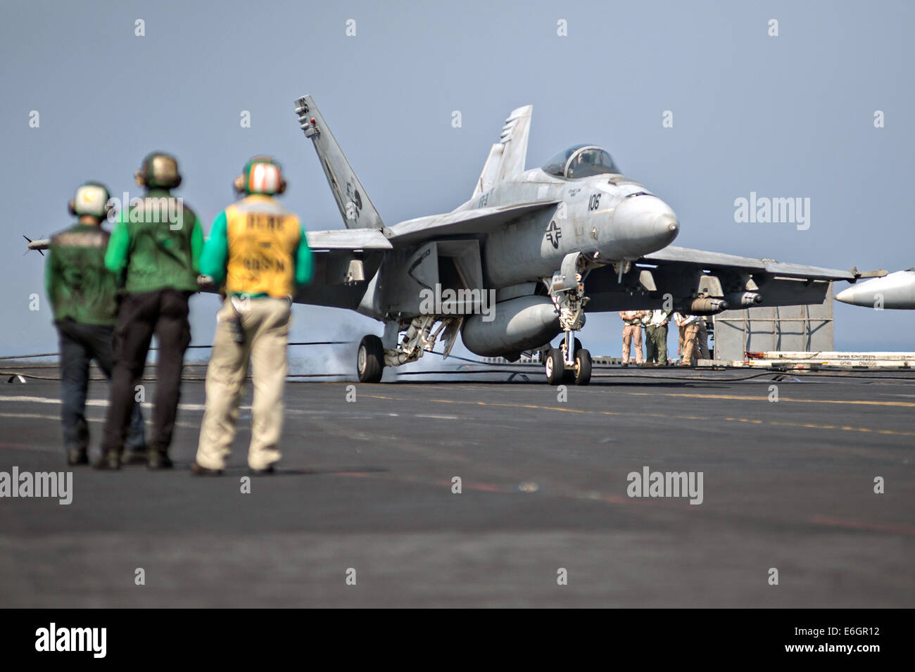 A US Navy F/A-18F Super Hornet fighter aircraft lands on the flight deck of the aircraft carrier USS George H.W. Bush after returning from a mission to support the Iraqi military August 14, 2014. President Obama authorized targeted airstrikes to protect U.S. personnel from extremists known as the Islamic State in Iraq and the Levant. Stock Photo
