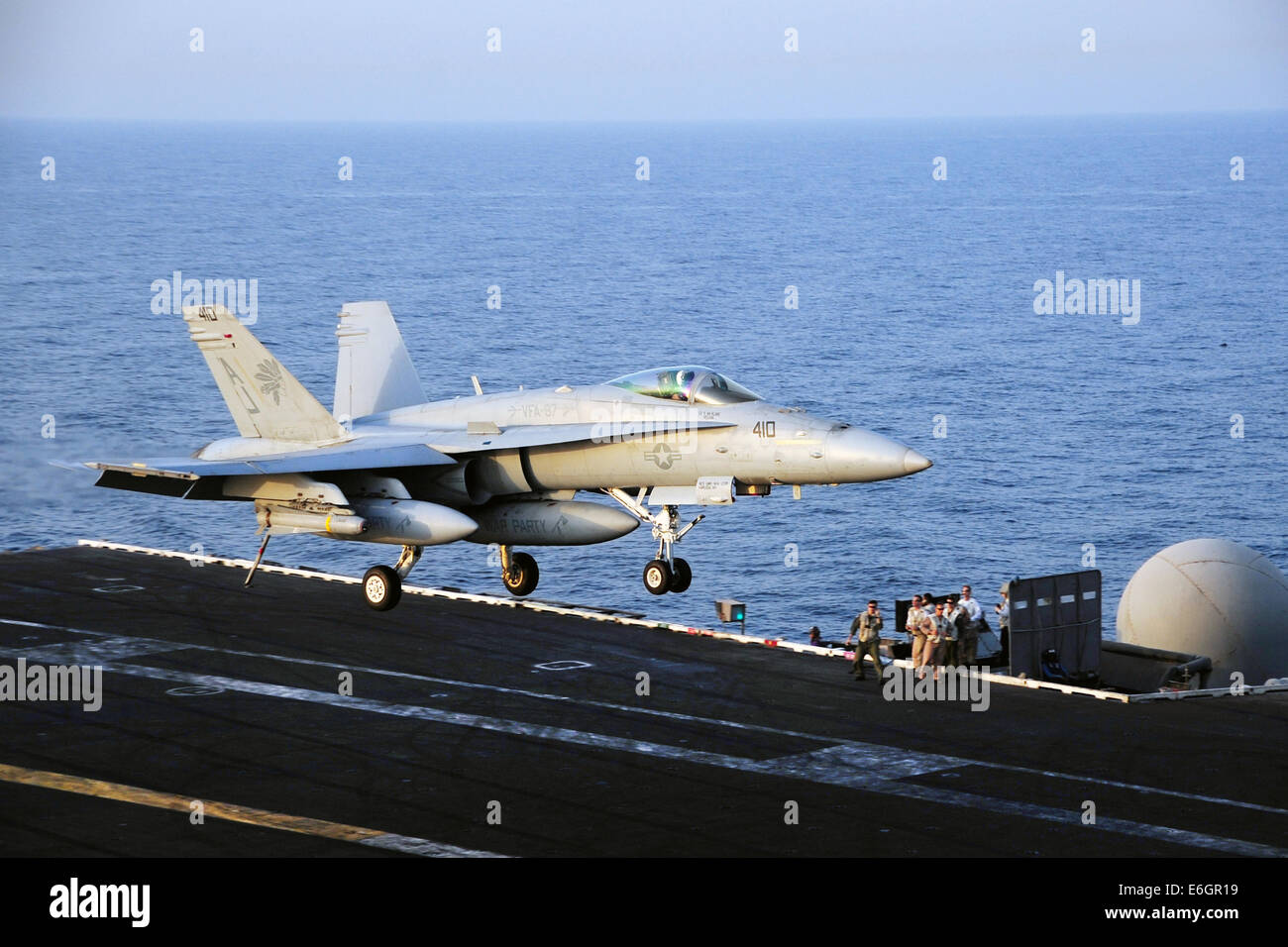 A US Navy F/A-18C Hornet fighter aircraft lands on the flight deck of the aircraft carrier USS George H.W. Bush after a mission to support the Iraqi military August 12, 2014. President Obama authorized targeted airstrikes to protect U.S. personnel from extremists known as the Islamic State in Iraq and the Levant. Stock Photo
