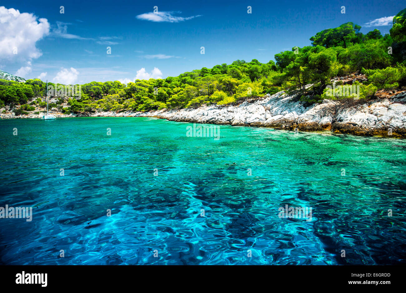 Beautiful uninhabited island, transparent blue water, romantic lagoon in Greece, moored luxury sail  boat in the bay Stock Photo