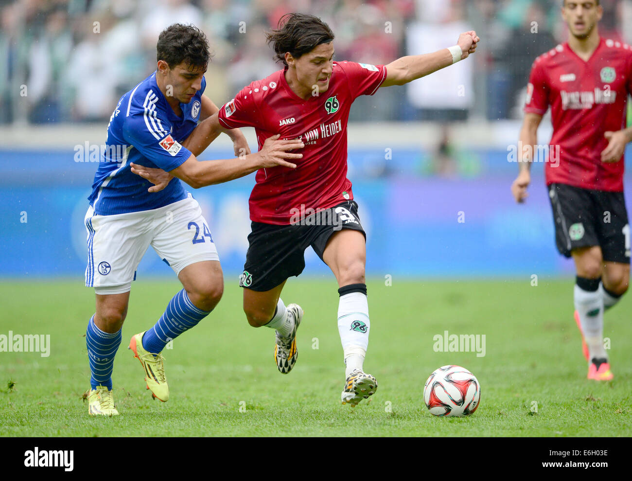 Hanover's Miiko Albornoz (R) and Schalke's Kaan Ayhan in action during the German Bundesliga match between Hannover 96 and FC Schalke 04 at HDI Arena in Hanover, Germany, 23 August 2014. Photo: PETER STEFFEN/dpa (ATTENTION: Due to the accreditation guidelines, the DFL only permits the publication and utilisation of up to 15 pictures per match on the internet and in online media during the match.) Stock Photo