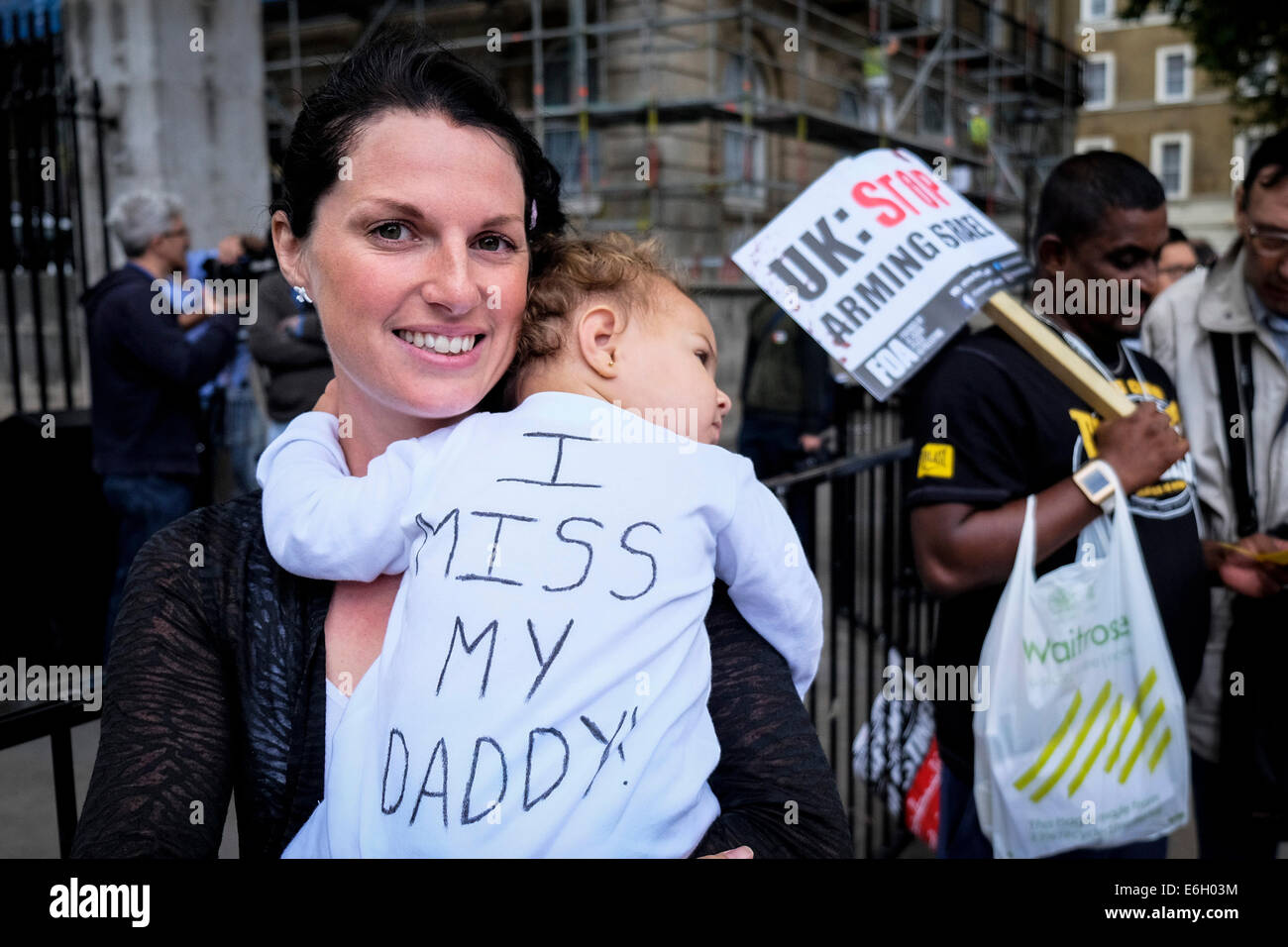 London, UK. 23rd August, 2014.  Sarah Angelina holds her 1 yr old daughter Ada at a demonstration protesting against government rules on family migration.  These rules introduce a new minimum-income threshold of £18,600 for “sponsoring the settlement in the UK of a spouse or partner of non-EEA nationality.   Ada's father is still in the Dominican Republic and unable to travel to the UK to be with his wife and baby daughter.  Credit:  Gordon Scammell/Alamy Live News Stock Photo