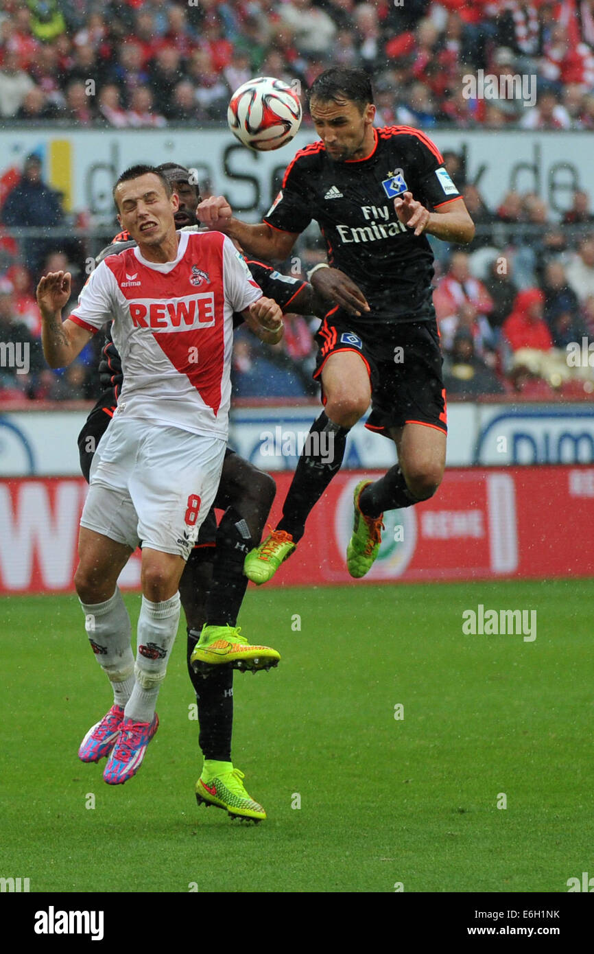 Cologne, Germany. 23rd Aug, 2014. Cologne's Adam Matuschyk and Hamburg's Johan Djourou (C) and Milan Badelj (R) in action during the German Bundesliga match between FC Koeln and Hamburger SV at RheinEnergieStadion in Cologne, Germany, 23 August 2014. Photo: MATTHIAS BALK/dpa (ATTENTION: Due to the accreditation guidelines, the DFL only permits the publication and utilisation of up to 15 pictures per match on the internet and in online media during the match.)/dpa/Alamy Live News Stock Photo