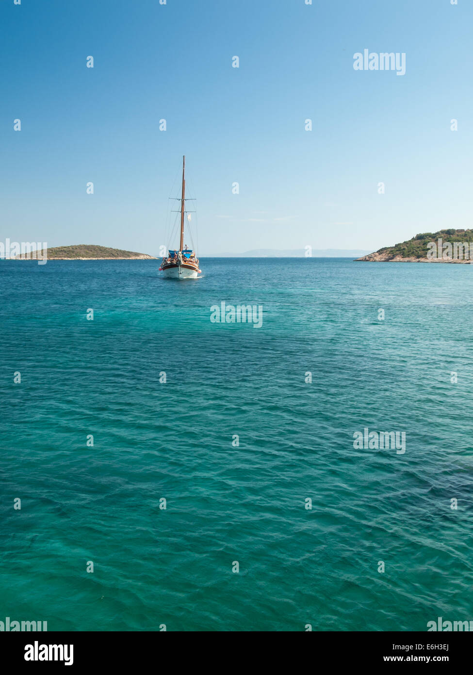 sailing boat passing between islands on the blue green waters of the turkish aegean coast. Stock Photo