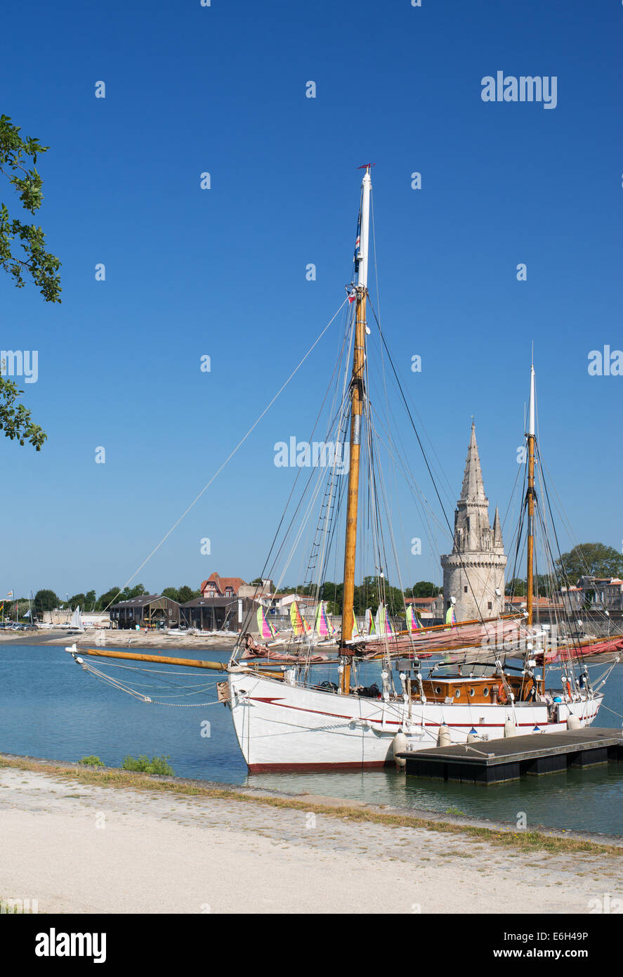 Old wooden sailing boat and Lantern Tower medieval lighthouse La Rochelle, Charente-Maritime, France, Europe Stock Photo