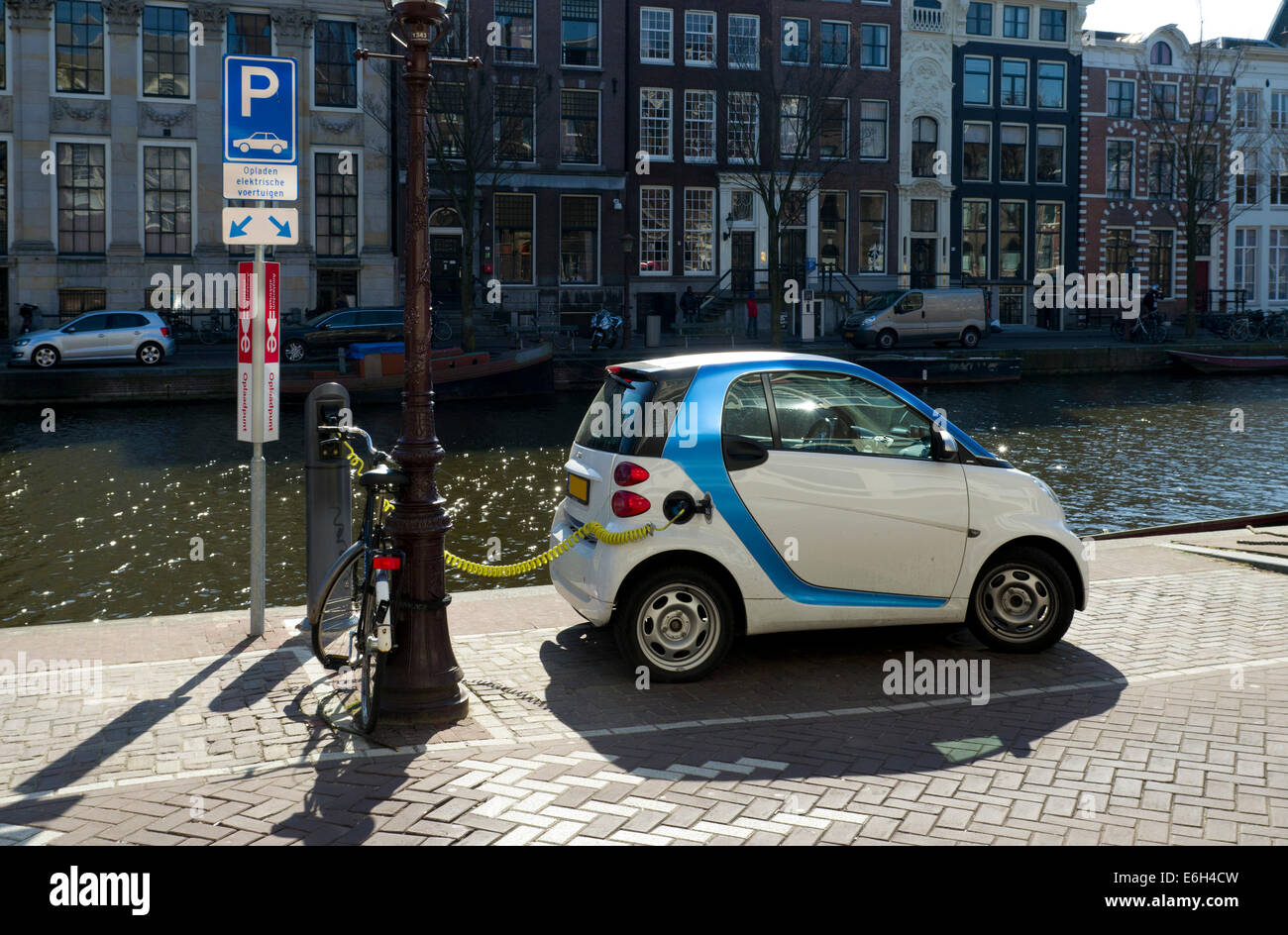electric car plugged in next to an amsterdam canal Stock Photo