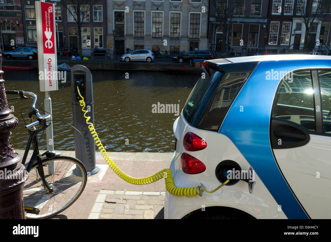 electric car plugged in next to an amsterdam canal Stock Photo