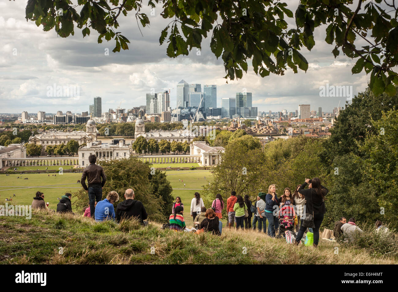London, UK - 23 August 2014: Visitors enjoy the view of the Canary Wharf skyscrapers from Greenwich park in London Stock Photo