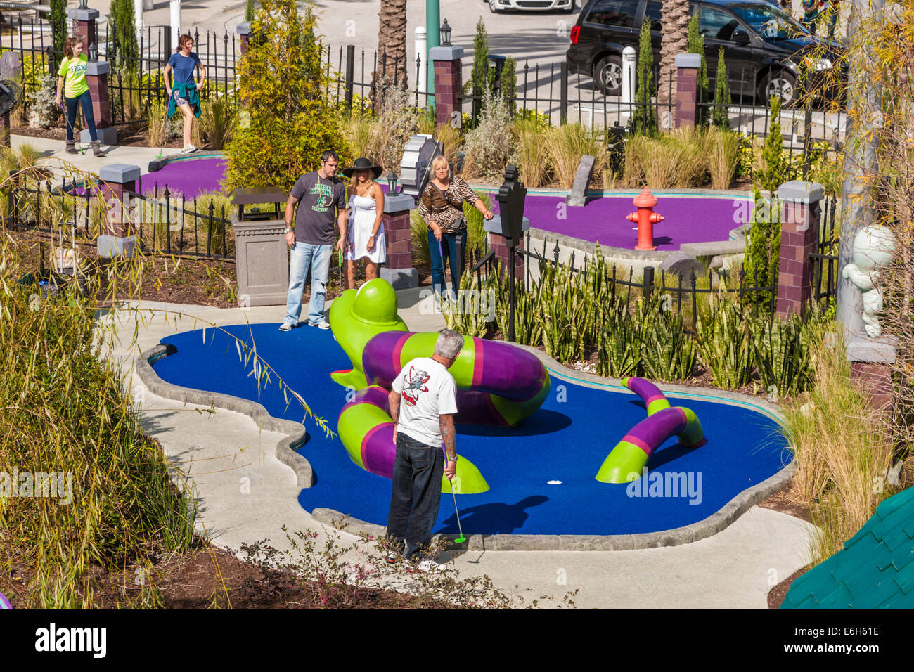 Teens and adults playing game of puttputt golf at Universal Studios in
