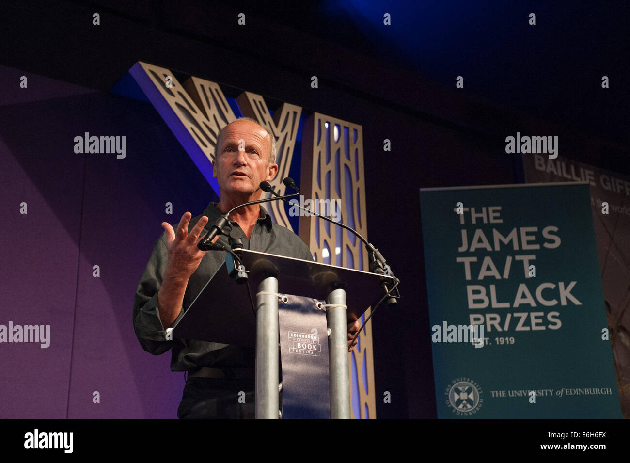 Edinburgh, UK. 23rd Aug, 2014. British writer Jim Crace gives a speech after receiving the James Tait Black Prizes' fiction category prize for his novel Harvest inspired by the daily toil of a shepherdess. The winners of Britain's oldest literary awards were announced on Saturday at an evening event during the ongoing Edinburgh International Book Festival. Credit:  Stringer/Xinhua/Alamy Live News Stock Photo