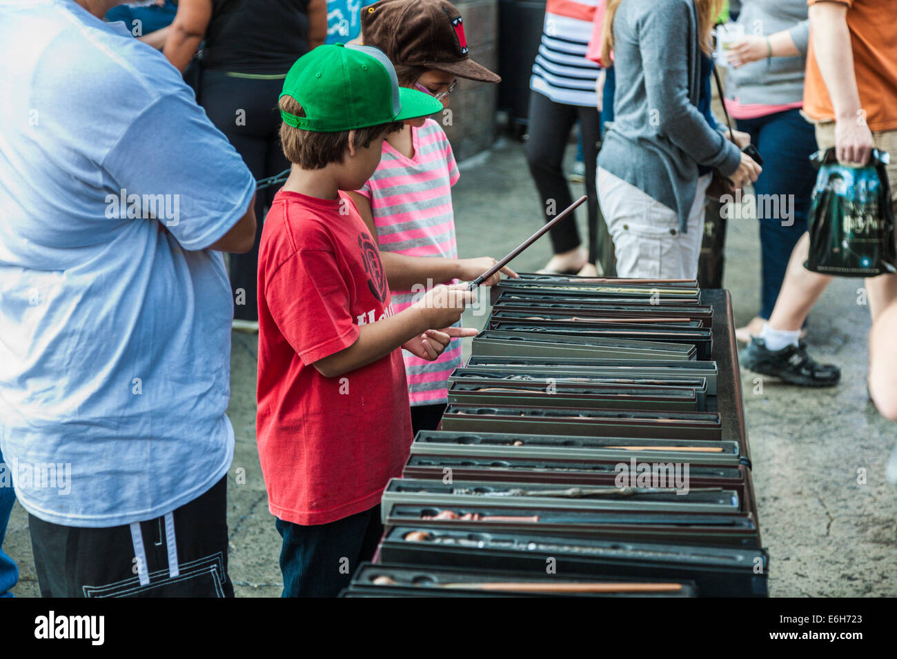 Young male child inspects magic wands for sale in The Wizarding World of Harry Potter at Universal Studios, Orlando, Florida Stock Photo