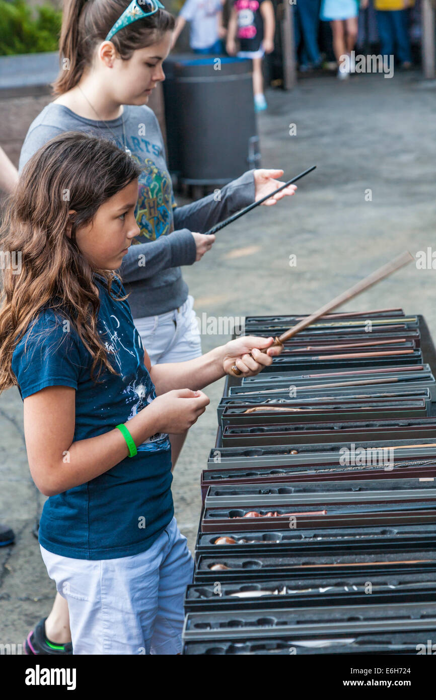 Young girls inspect magic wands for sale in The Wizarding World of Harry Potter at Universal Studios, Orlando, Florida Stock Photo