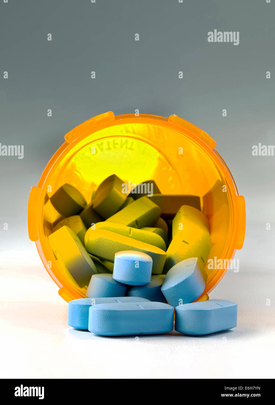 Little blue pills in a yellow pill container Stock Photo Alamy