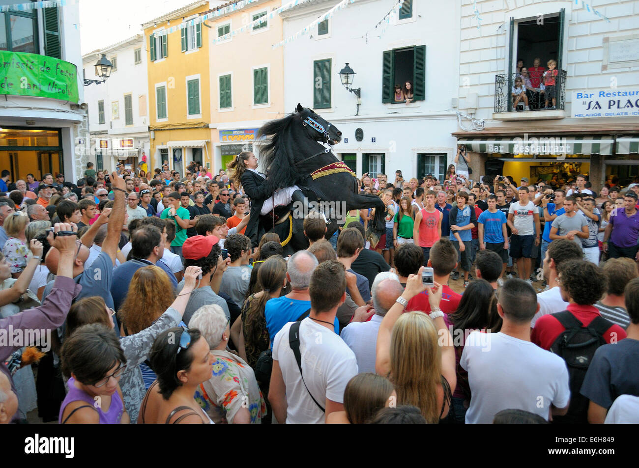 A horse rearing with a woman rider in the crowd, typical horse riding during the traditional celebration of San Nicolas in Menor Stock Photo