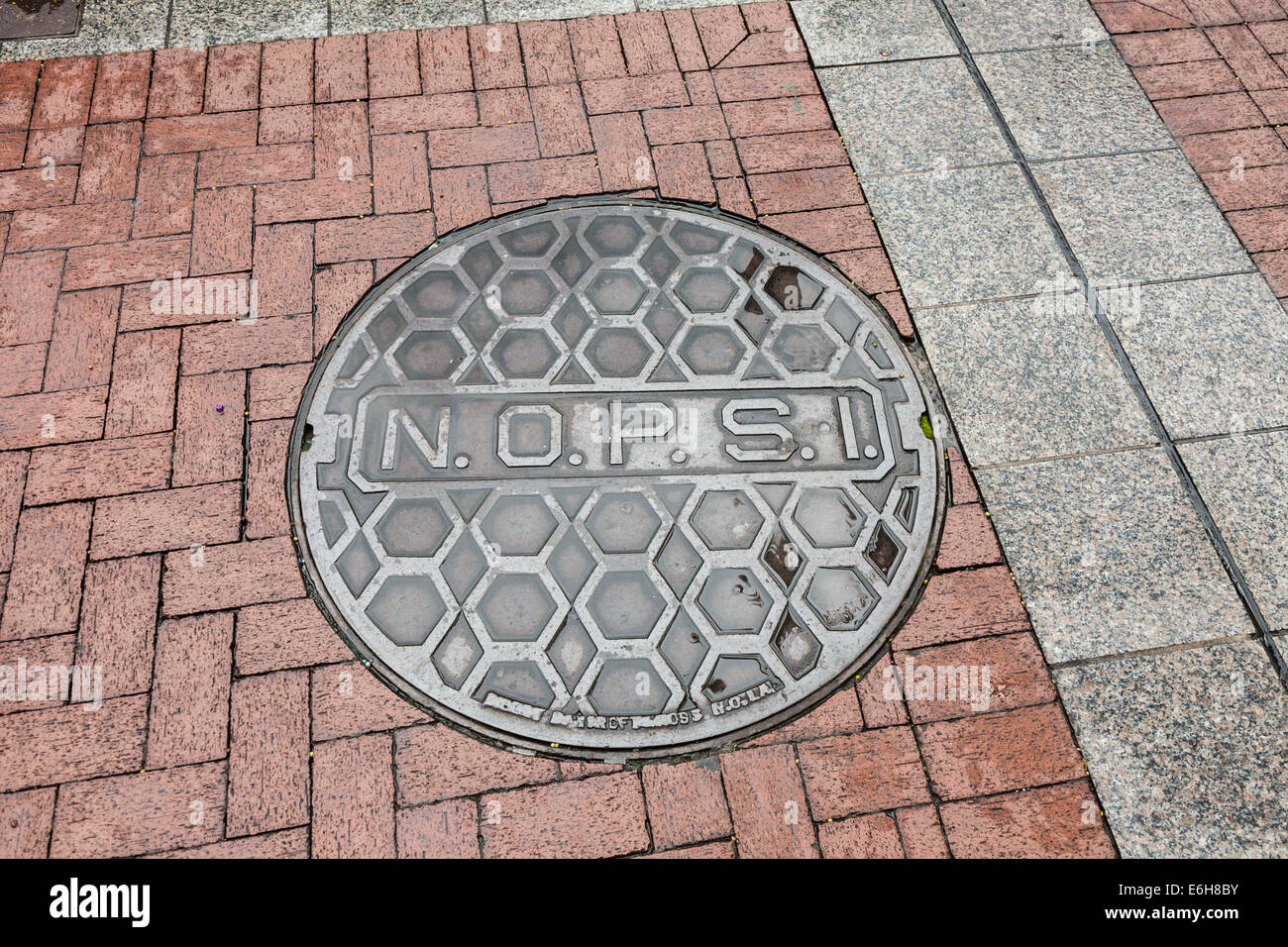 New Orleans Public Service Inc cast iron utility manhole cover on the sidewalk in New Orleans, Louisiana Stock Photo