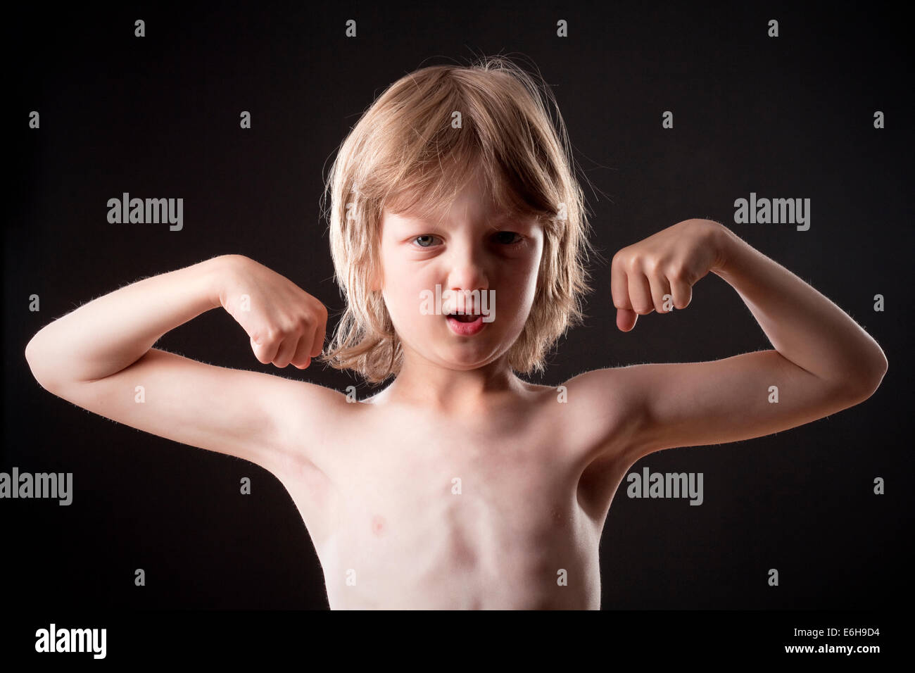 Boy with Blond Hair Showing his Muscles Stock Photo