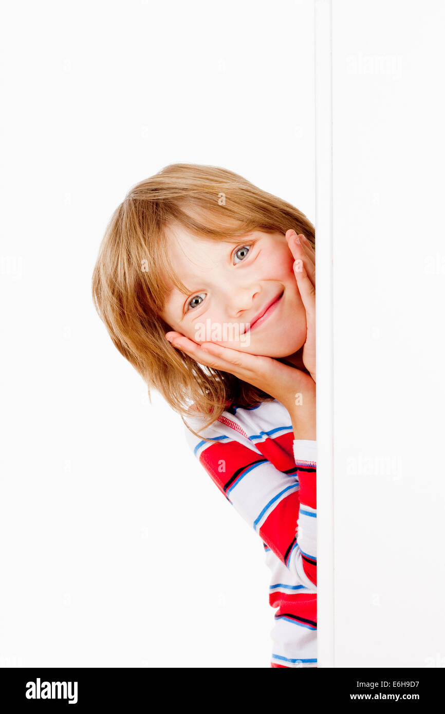 Boy With Blond Hair Peeking Out From Behind A White Board Smiling Stock Photo