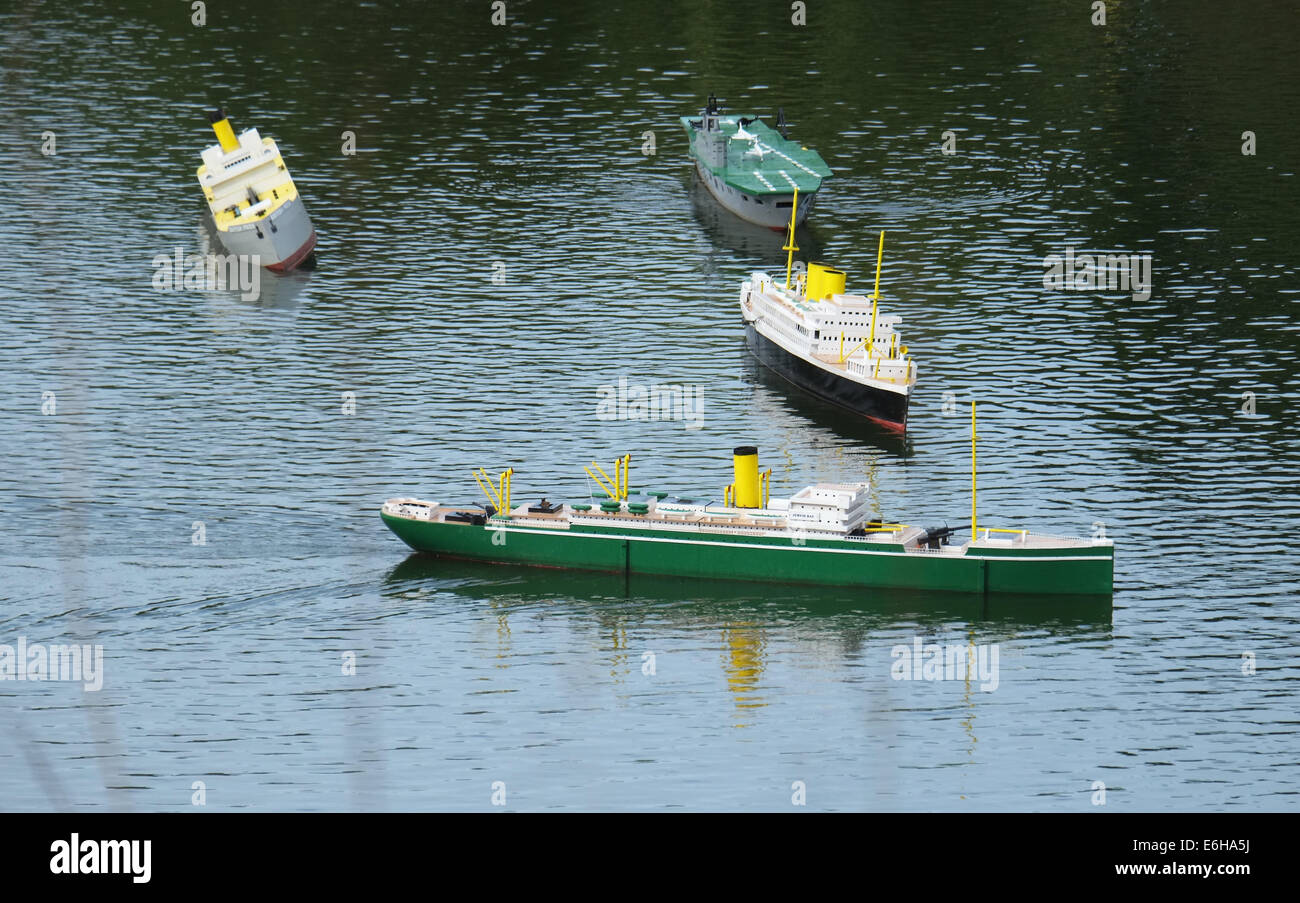 Model ships on lake enacting naval warfare. Stock Photo