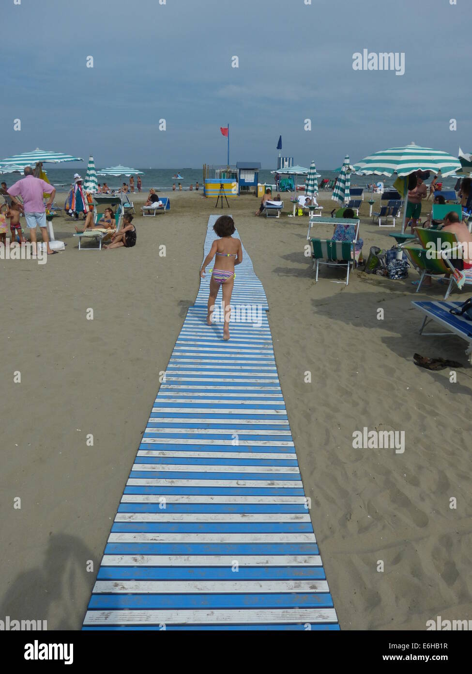 A Child Runs To The Sea On A Pretty Walkway Across Alberoni