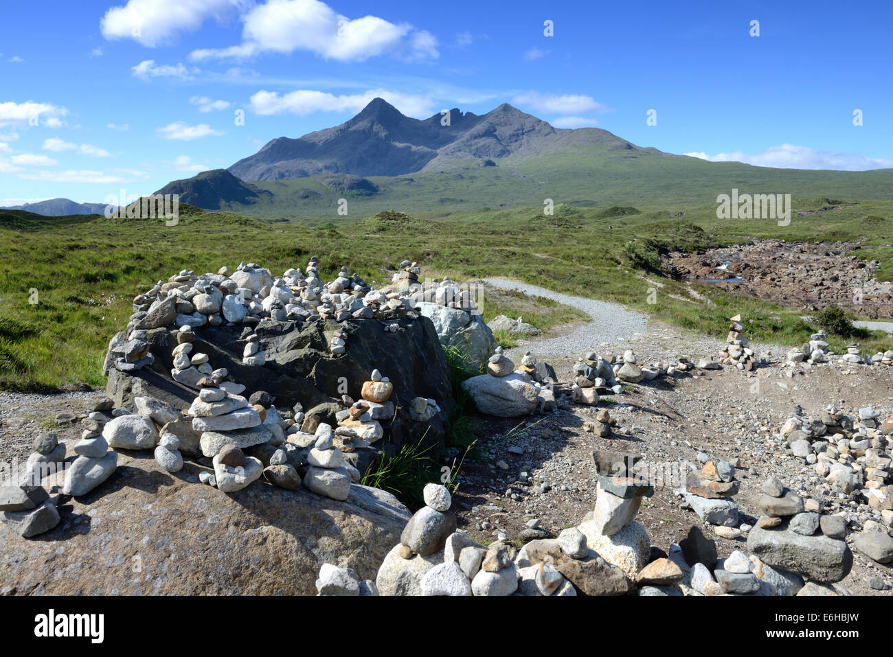 Stones placed on rocks by visitors at Sligachan viewpoint and showing the Black Cuillin ridge on Skye, Scotland Stock Photo