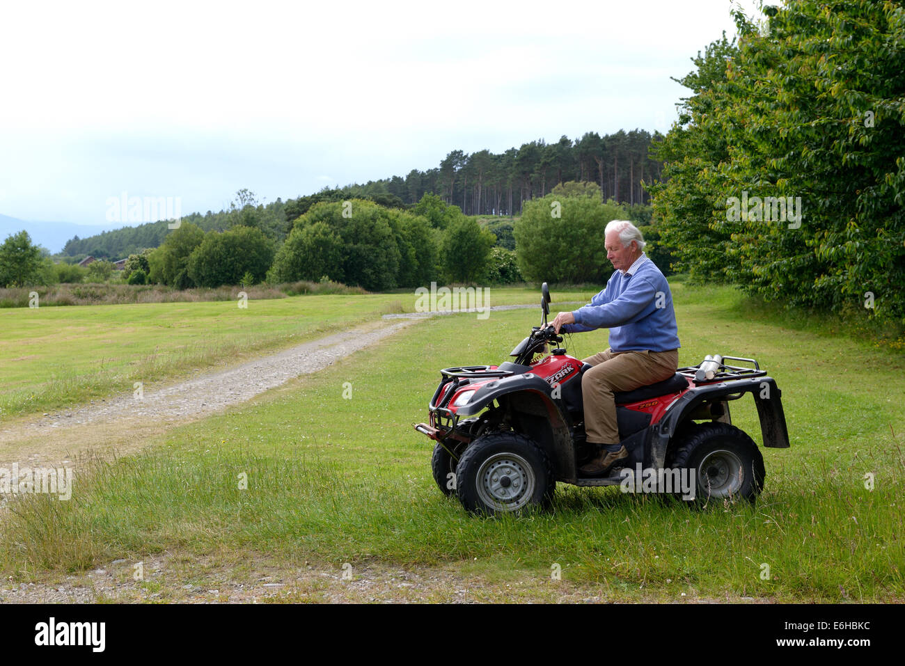 A senior man riding an all terrain vehicle Stock Photo